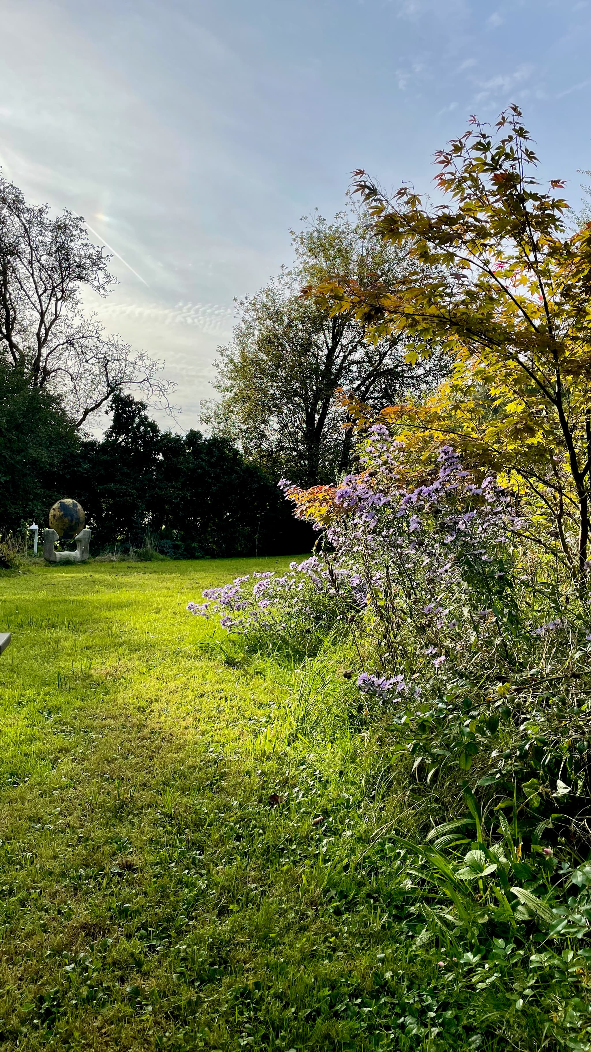 Idyllischer Gartenweg mit Blumenbeeten und natürlicher Umgebung
